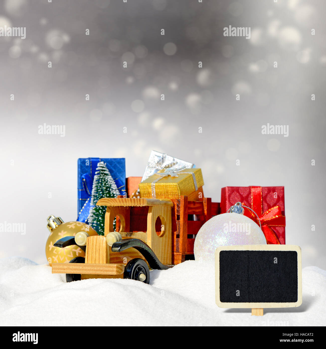 Weihnachtskarte. Spielzeug-LKW mit Geschenken, Neujahr Tanne und Kugeln im Schnee Stockfoto