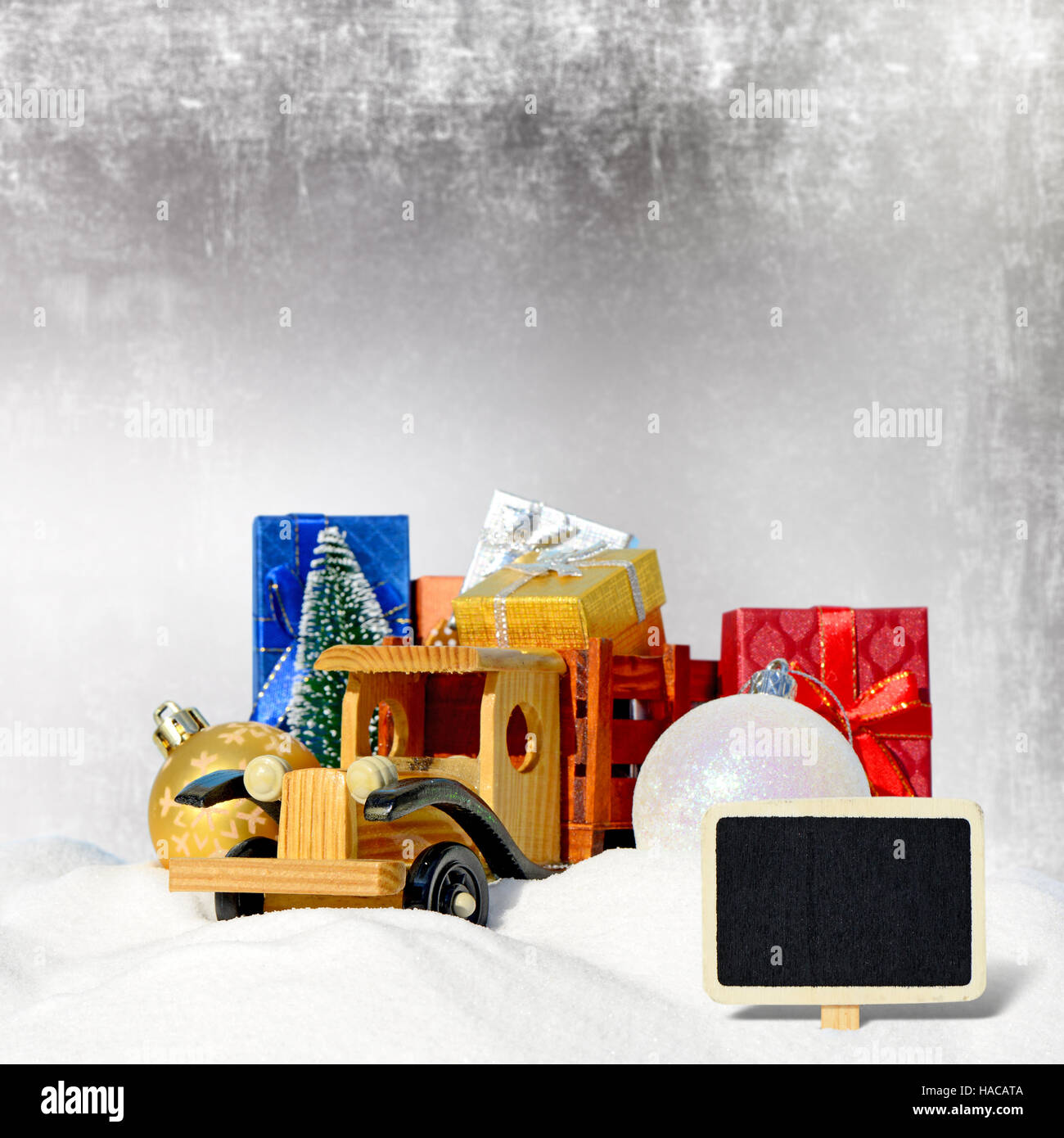 Weihnachtskarte. Spielzeug-LKW mit Geschenken, Neujahr Tanne und Kugeln im Schnee Stockfoto