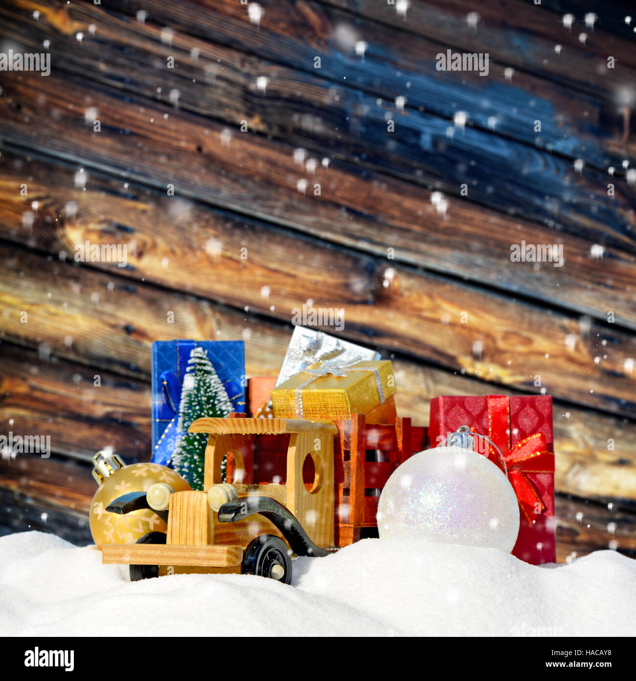 Weihnachten Hintergrund. Spielzeug-LKW mit Geschenken, Neujahr Tanne und Kugeln im Schnee Stockfoto