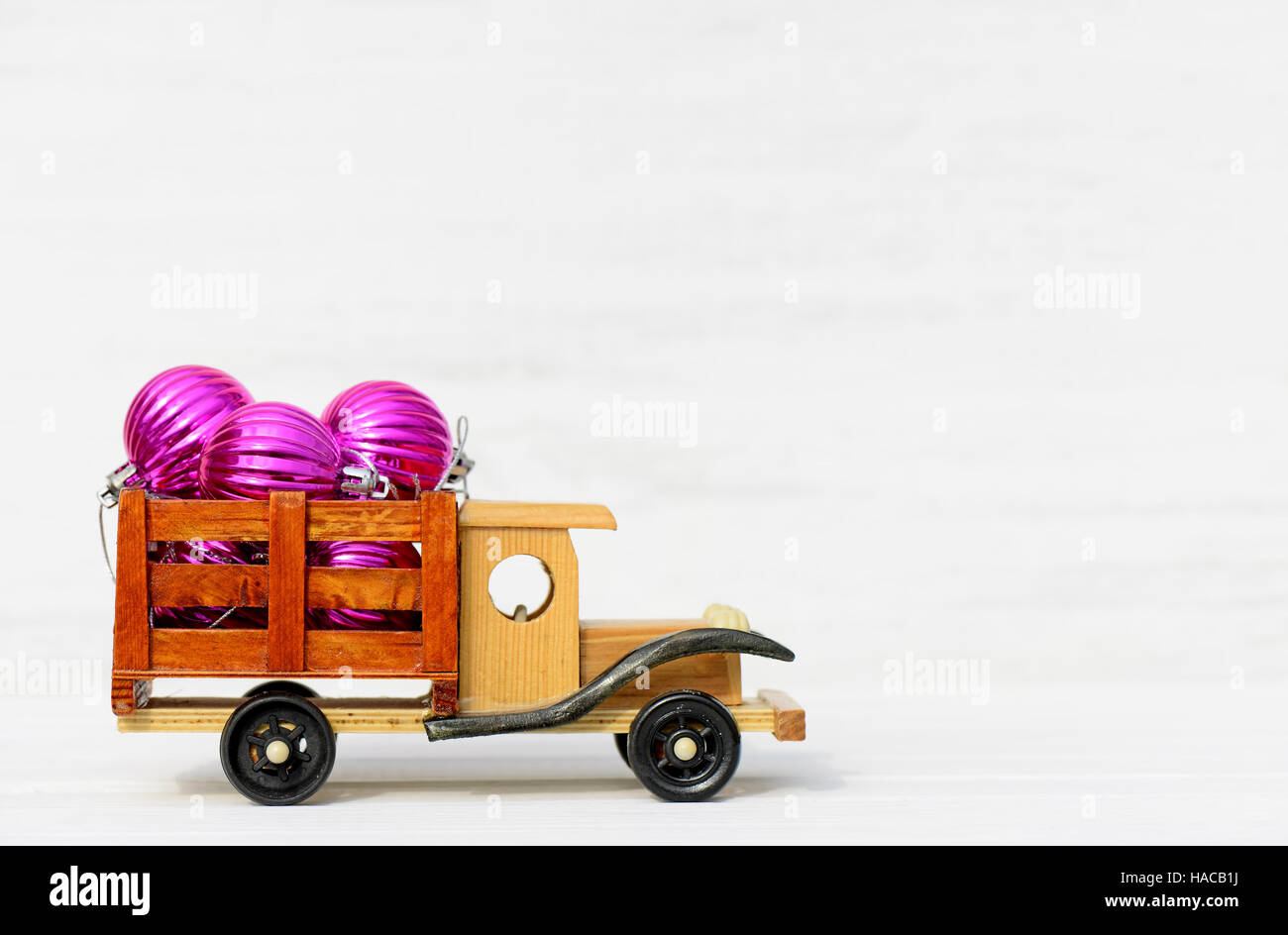Spielzeugauto mit Weihnachten Spielzeug auf einem hölzernen weißen Hintergrund Stockfoto
