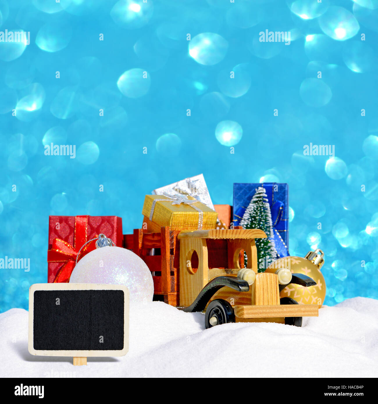 Spielzeugauto LKW mit Geschenken, Neujahr Tanne und Kugeln im Schnee als Weihnachten Hintergrund Stockfoto