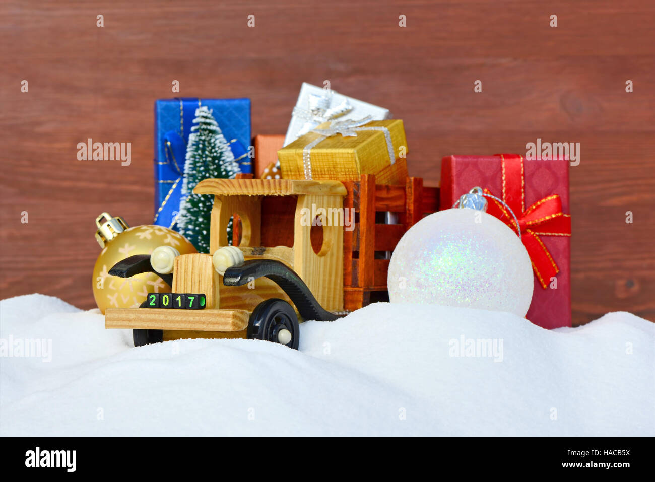 Weihnachten Hintergrund. Spielzeug-LKW mit Geschenken, Neujahr Tanne und Kugeln im Schnee Stockfoto