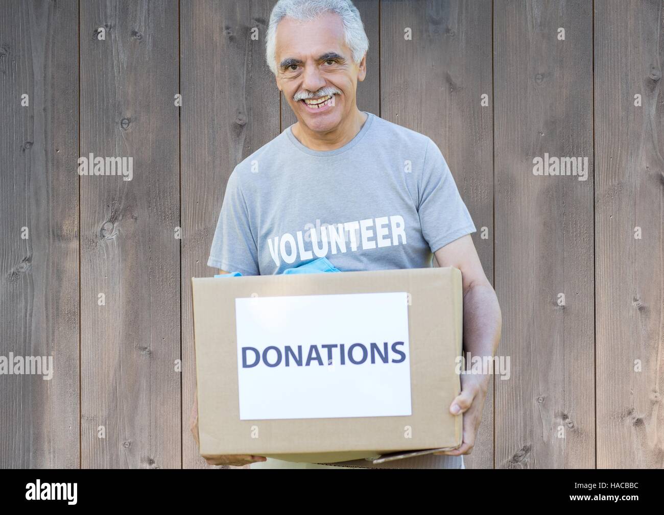 Lächelnde männlichen Freiwilligen halten Spenden box Stockfoto