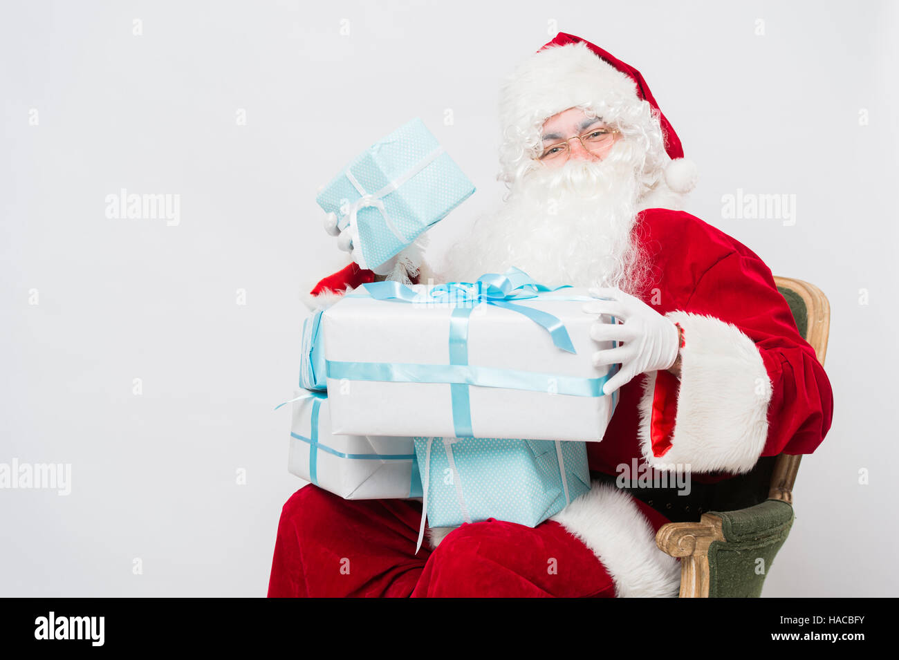 Foto von happy Santa Claus mit Giftboxes Blick auf Sie Stockfoto