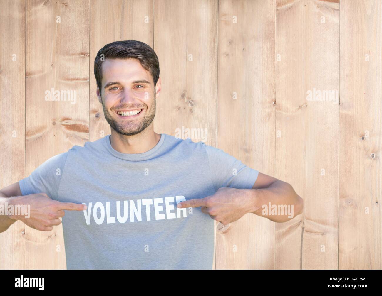 Lächelnder Mann zeigte auf freiwillige Titel auf seinem t-Shirt Stockfoto