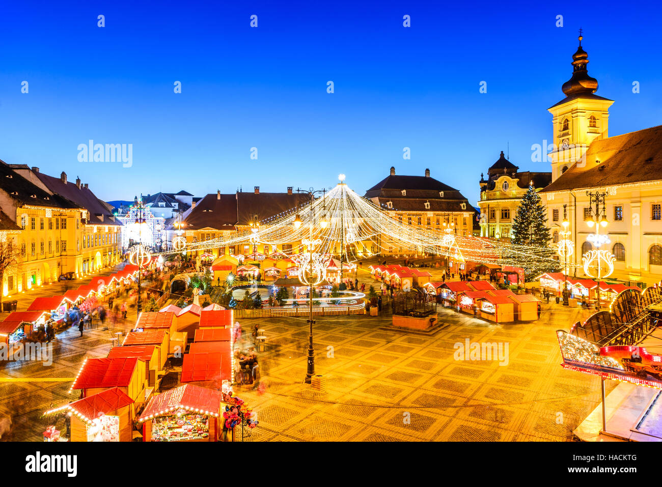 Sibiu, Rumänien. Nacht-Bild mit Touristen am Weihnachtsmarkt im großen Markt der mittelalterlichen Stadt Sibiu, Transylvania Wahrzeichen. Stockfoto