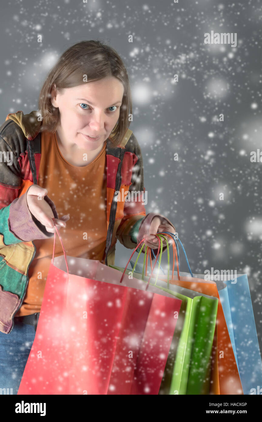 Glückliche Frau mit Einkaufstüten über Schnee Hintergrund. Stockfoto