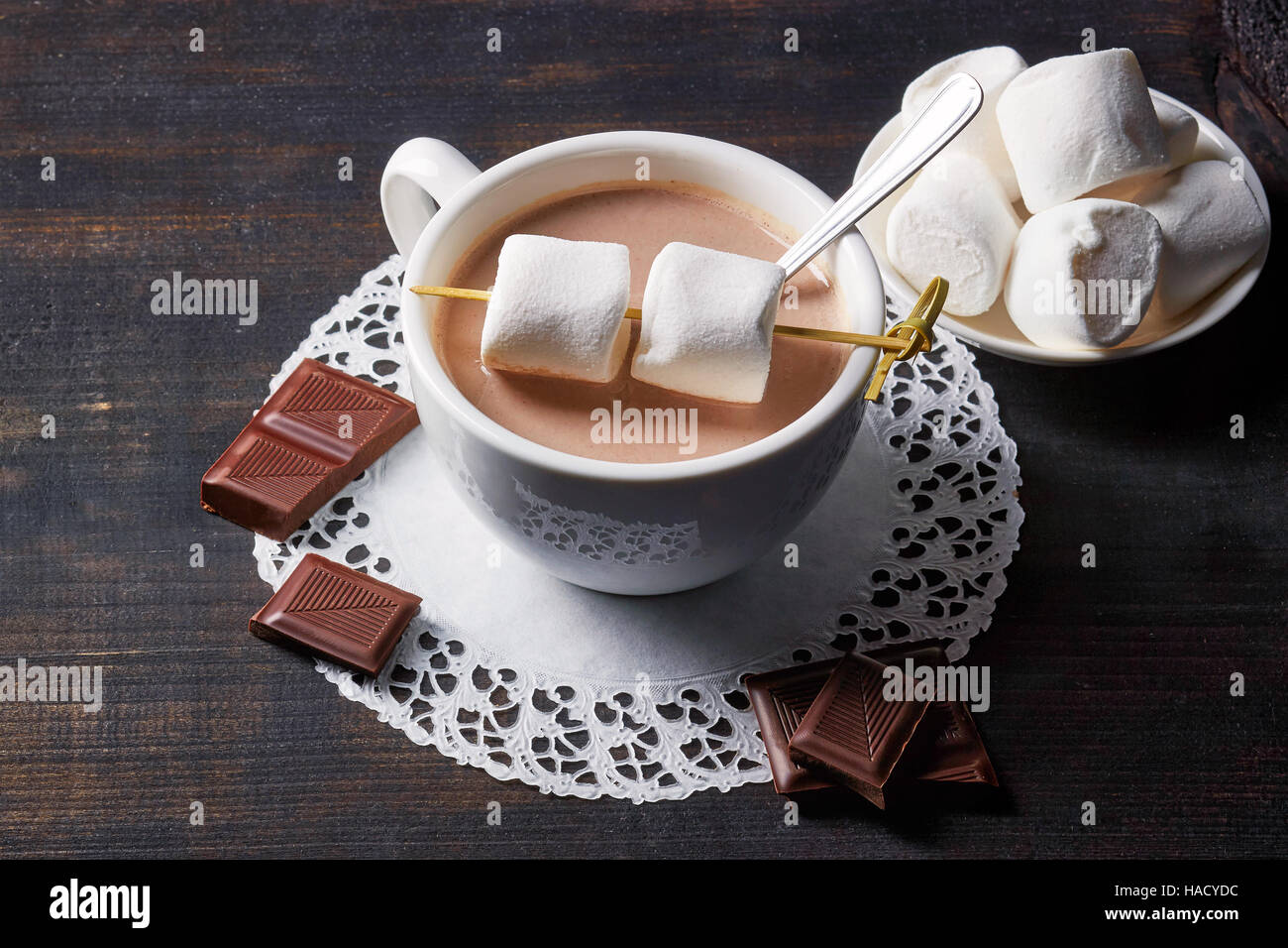Tasse heißen Kakao Getränk mit Süßigkeiten auf dunklen Holztisch Stockfoto