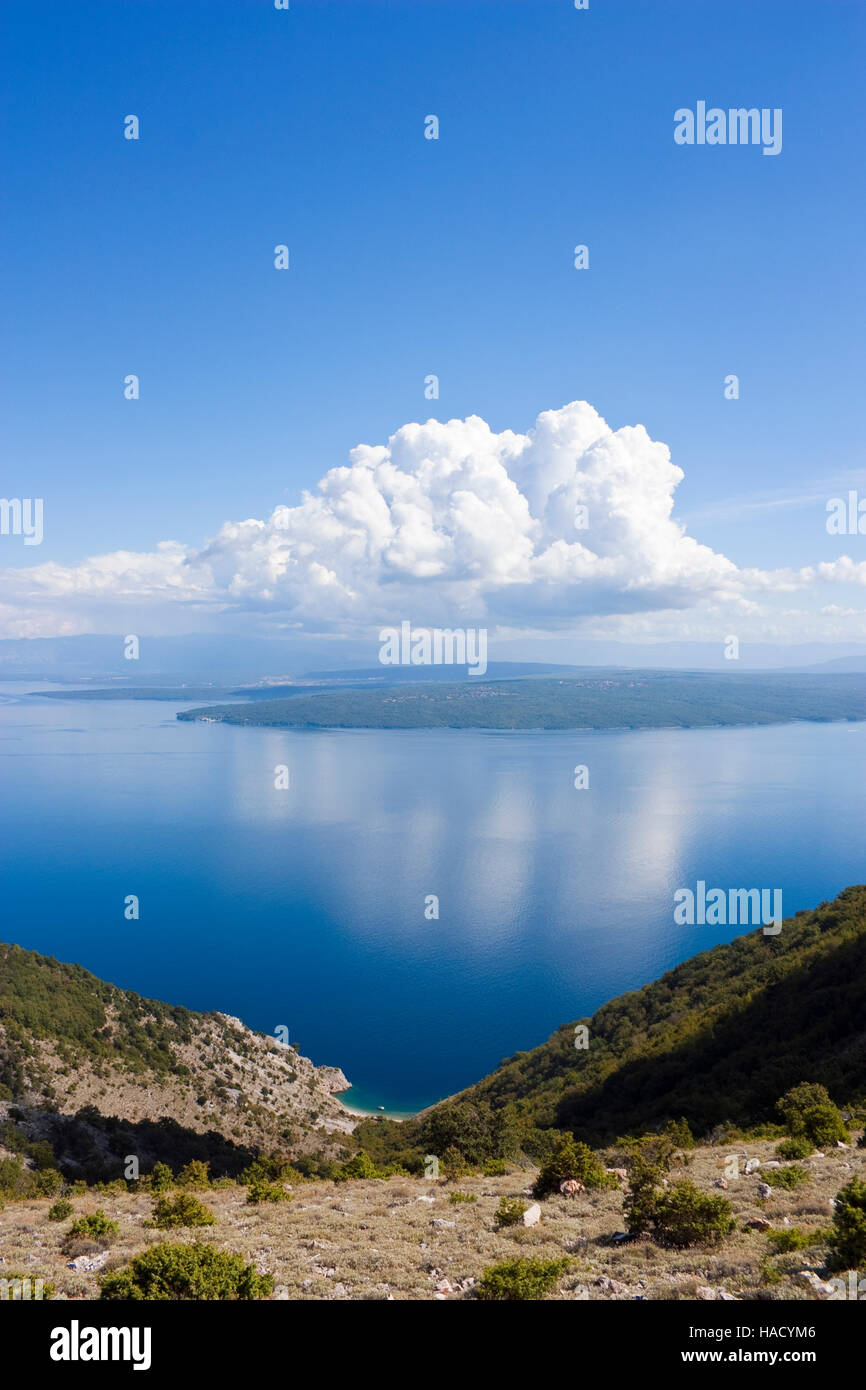 Kleine Bucht auf Kroatien Insel cres, Blick auf die Insel Krk mit einigen Wolken am blauen Himmel Stockfoto