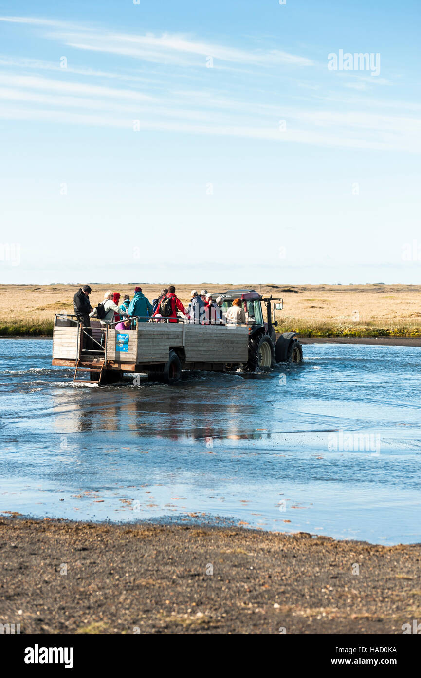 Ingolfshofdi Nature Reserve, Island - Touristen, die Überquerung eines Flusses in einem Traktor gezogenen Wagen nach einem Besuch in der Vogel-Kolonie. Stockfoto