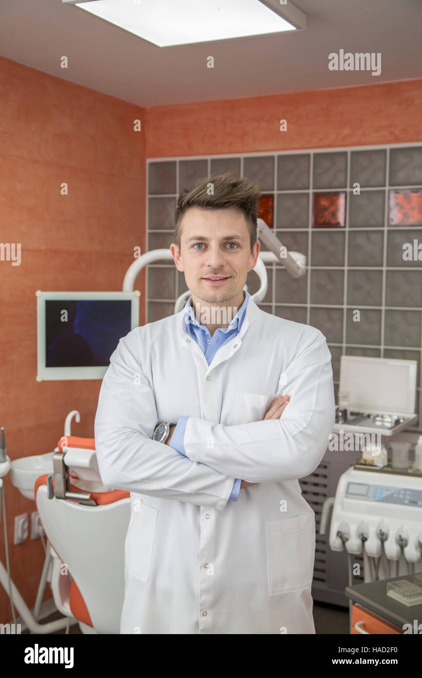 Junge männliche Zahnarzt über Arztpraxis Hintergrund Stockfoto