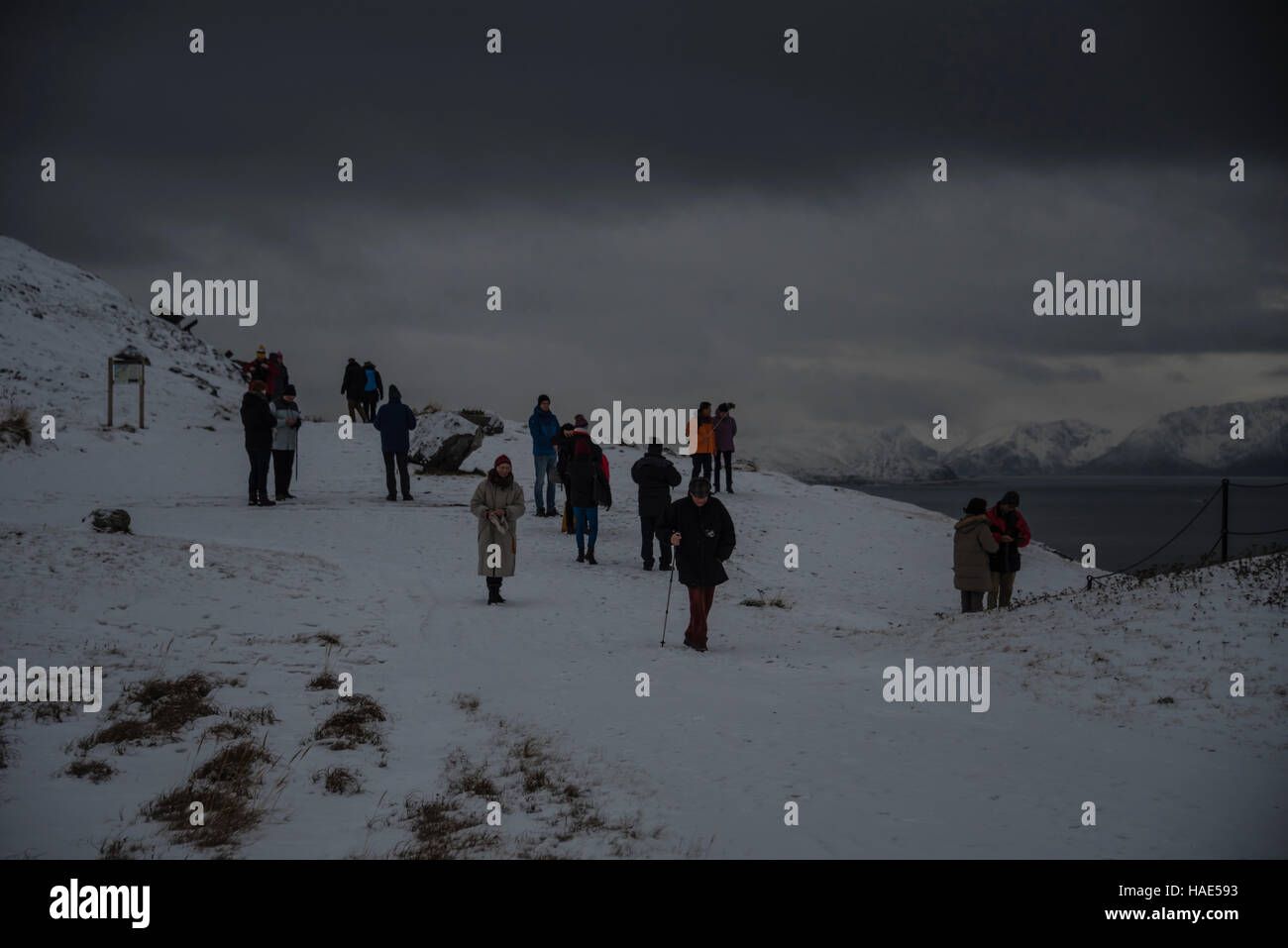 Touristen blicken auf die Stadt Hammerfest im Norden Norwegens unter winterlichen Bedingungen. Stockfoto