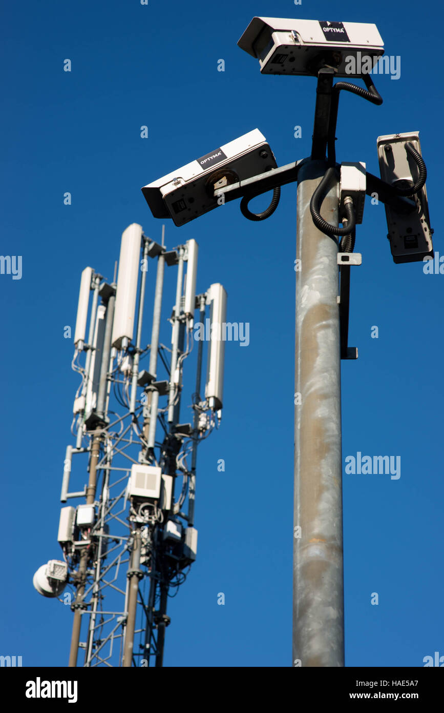 CCTV-Überwachungskameras und einem Mobiltelefon Mast vor einem strahlend blauen Himmel Stockfoto