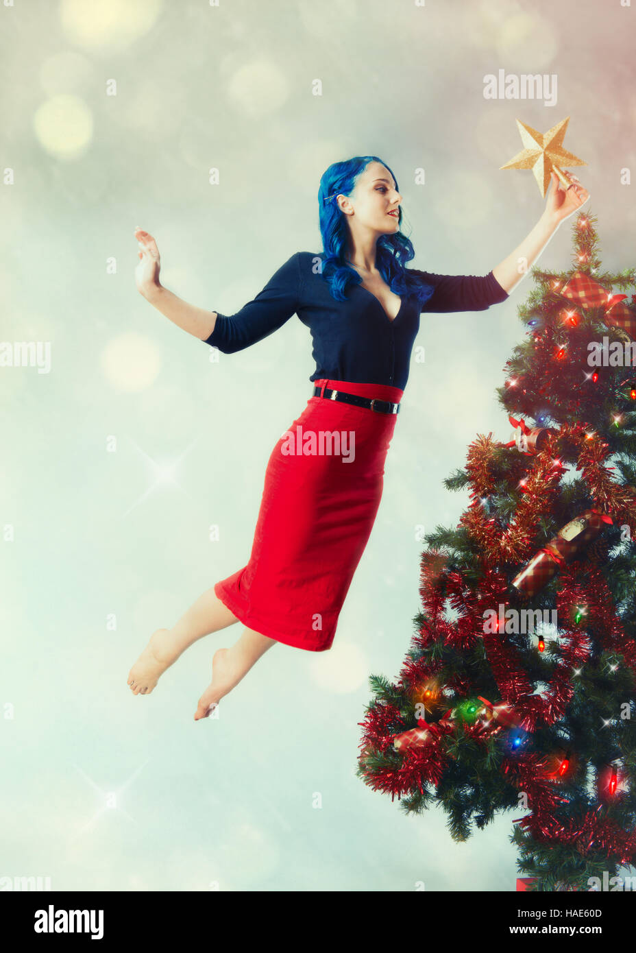 Frau schweben, indem der Star auf einen Weihnachtsbaum Stockfoto