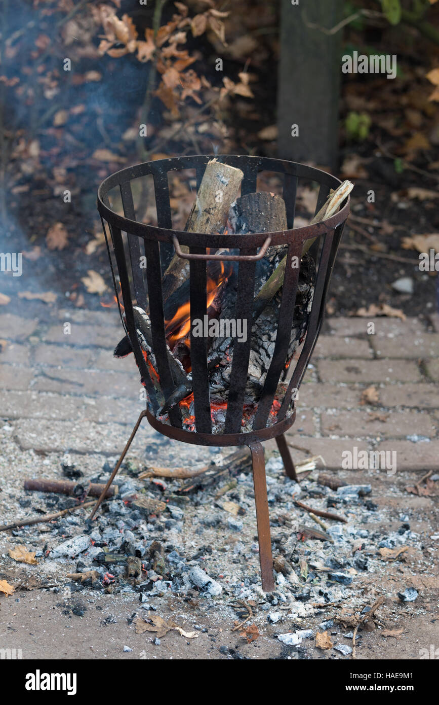 Feuerstelle im Freien mit brennendem Holz und Asche auf den Boden Stockfoto