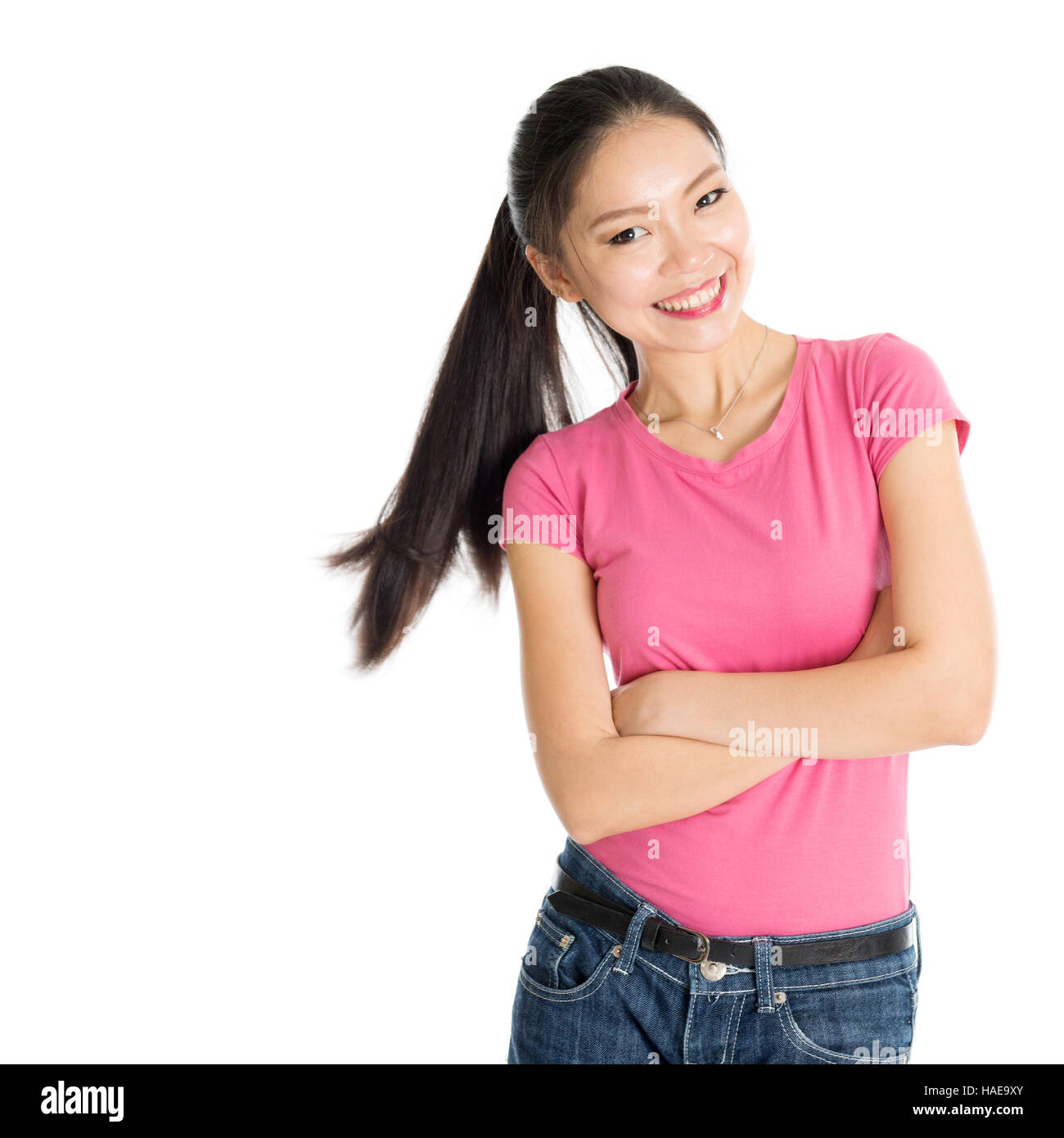Porträt der glückliche junge asiatische Mädchen in rosa Hemd und Jeans mit Pferdeschwanz Haare, stehen isoliert auf weißem Hintergrund. Stockfoto