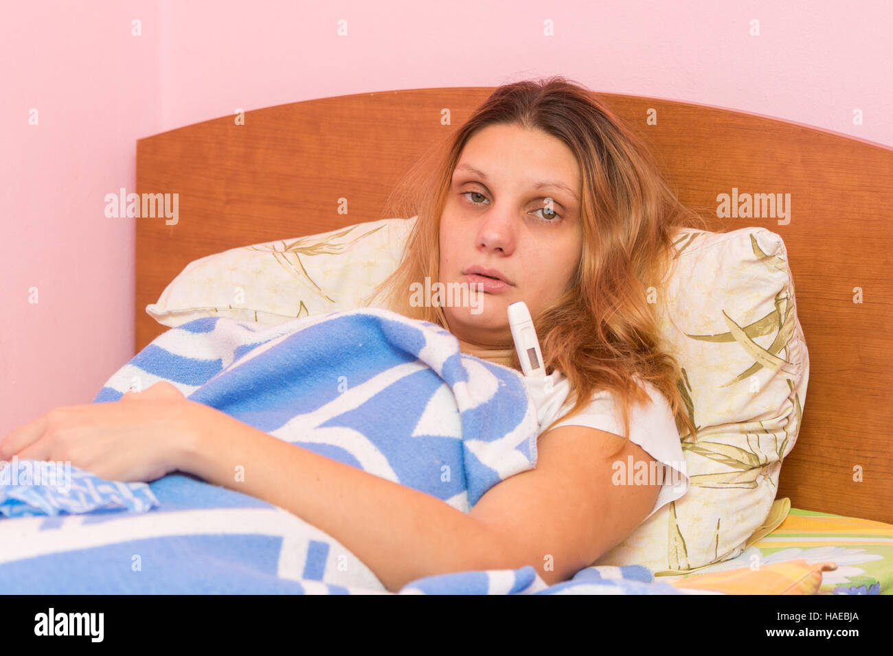 Kranke Mädchen und misst die Temperatur von einem elektronischen Thermometer Stockfoto