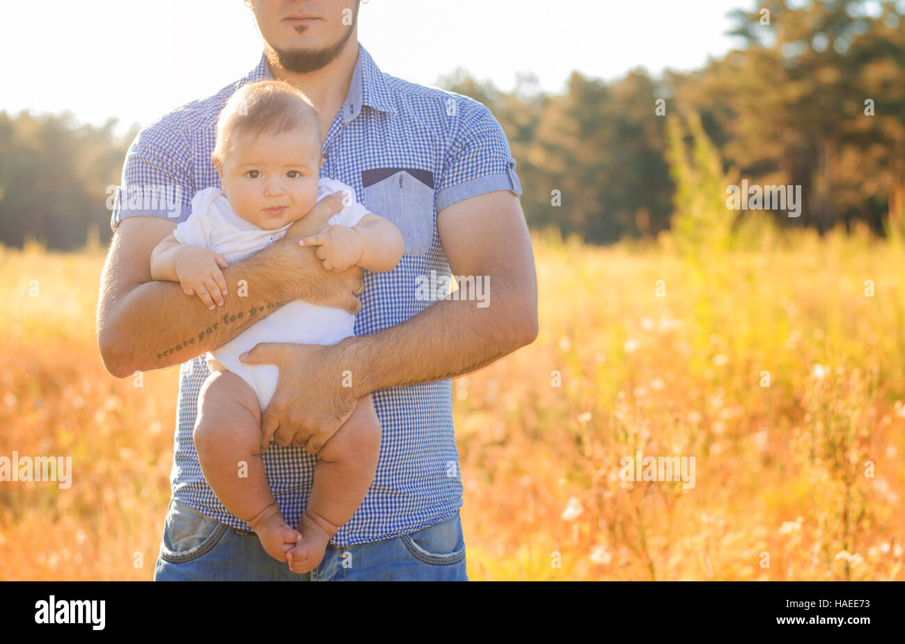 Ein junger Vater mit einem Baby im Arm. Laufen Sie Herbstabend im Freien. Stockfoto