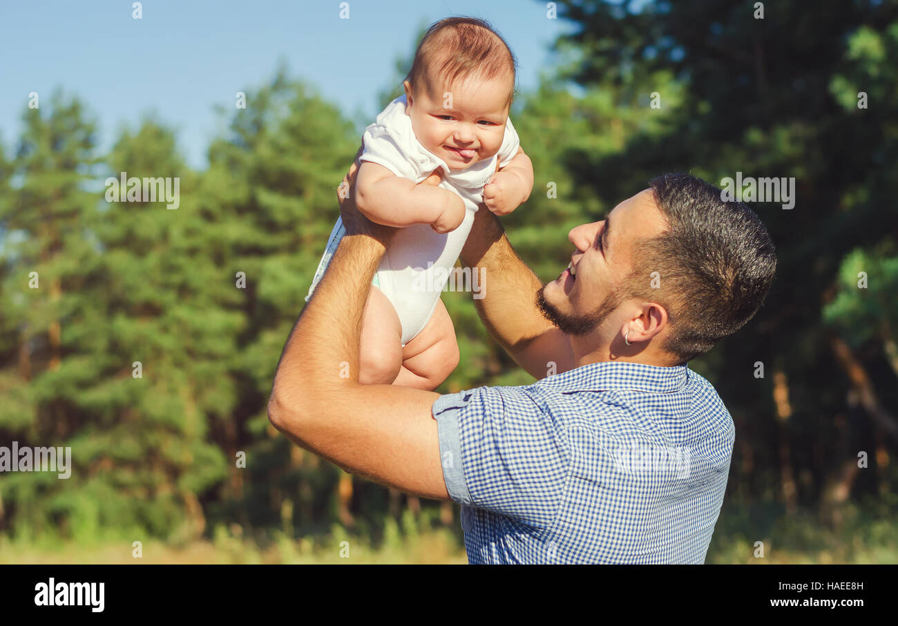 Ein junger Vater mit einem Baby im Arm. Laufen Sie Herbstabend im Freien. Stockfoto