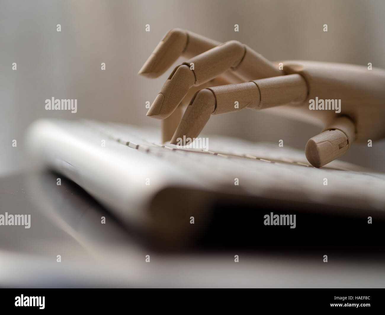 Wooden dummy Hand auf einer Computertastatur. Stockfoto