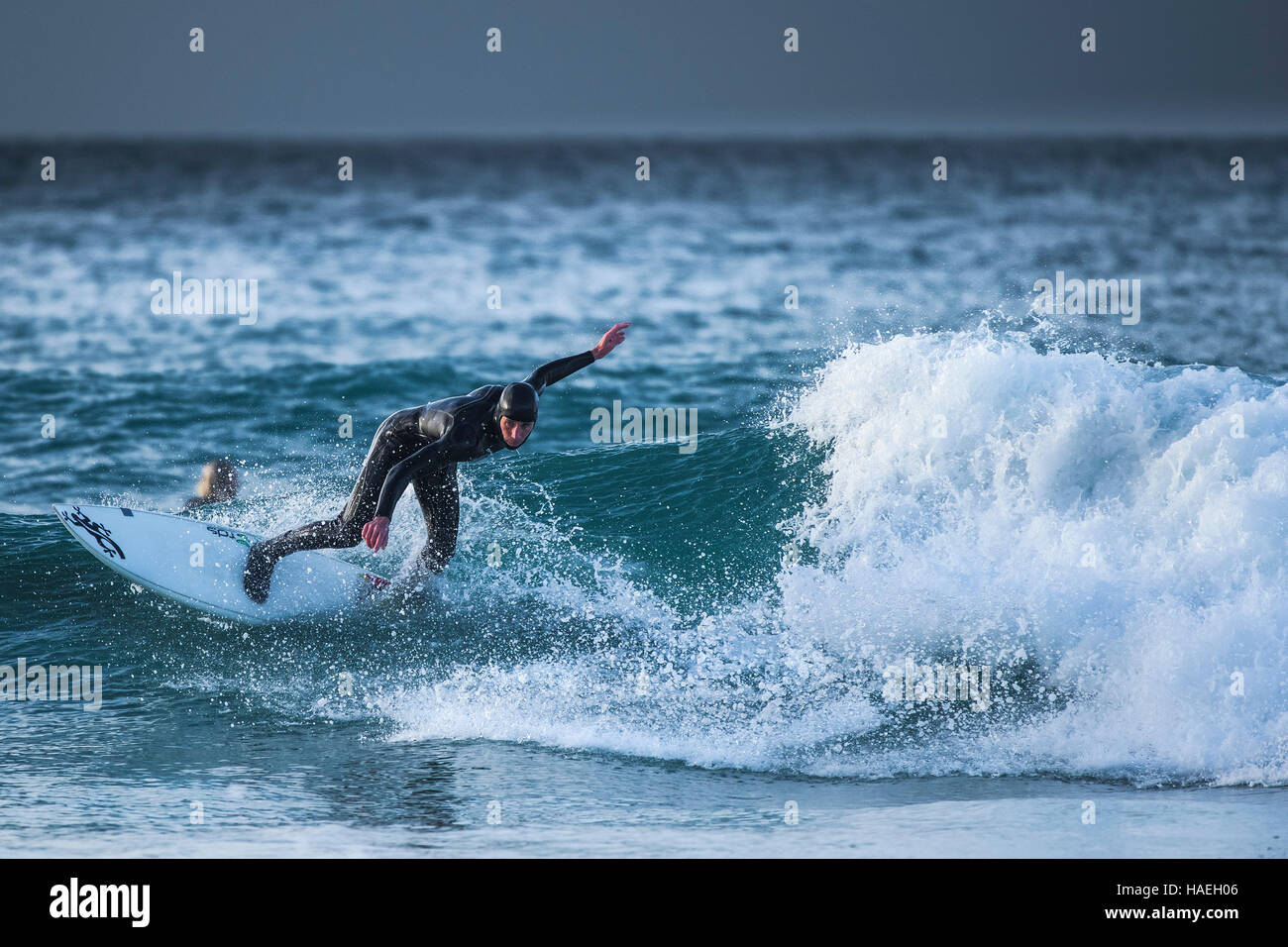 Ein Surfer reitet eine Welle an Fistral in Newquay, Cornwall. Stockfoto