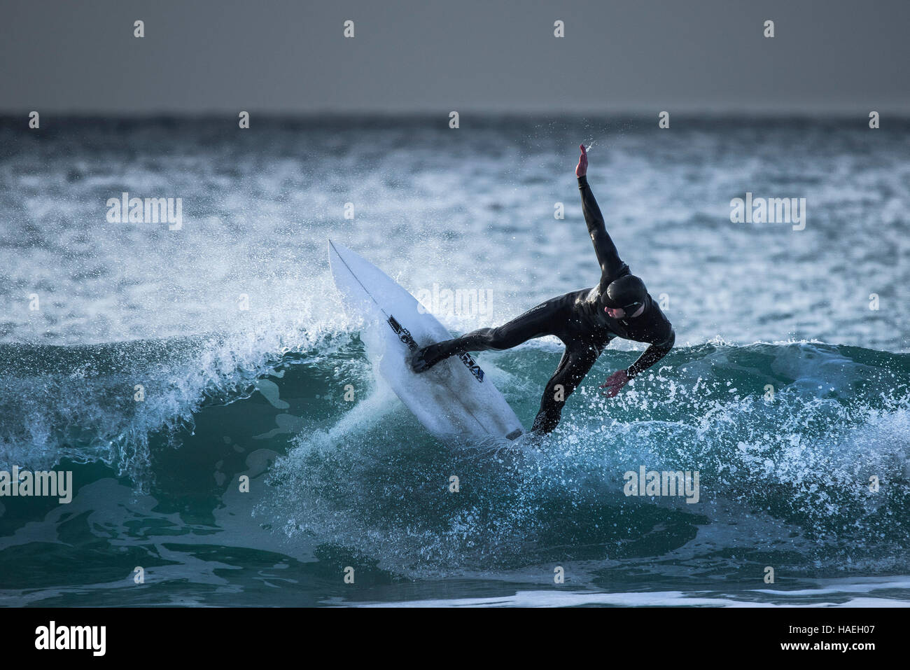 Ein Surfer reitet eine Welle an Fistral in Newquay, Cornwall. Stockfoto