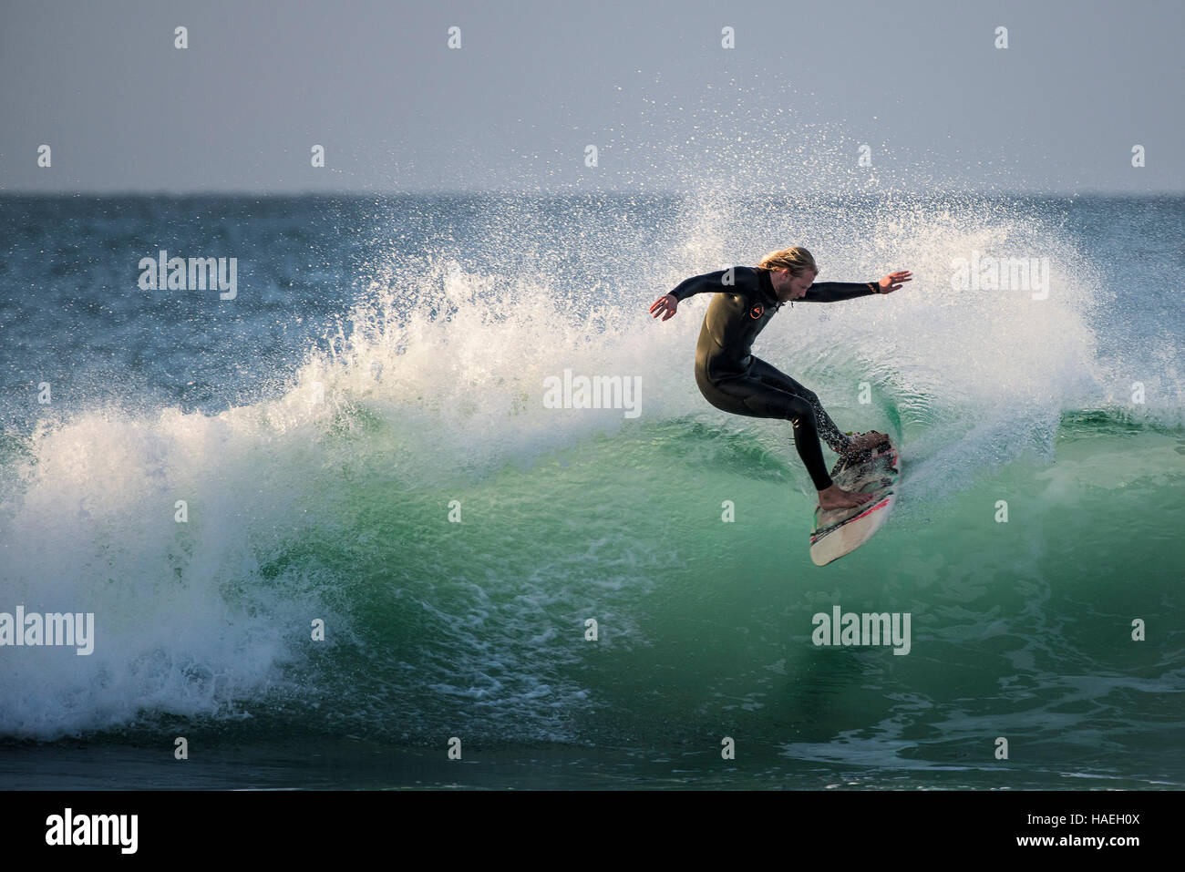 Ein Surfer in einer spektakulären Aktion auf den Fistral in Newquay, Cornwall, England. Stockfoto