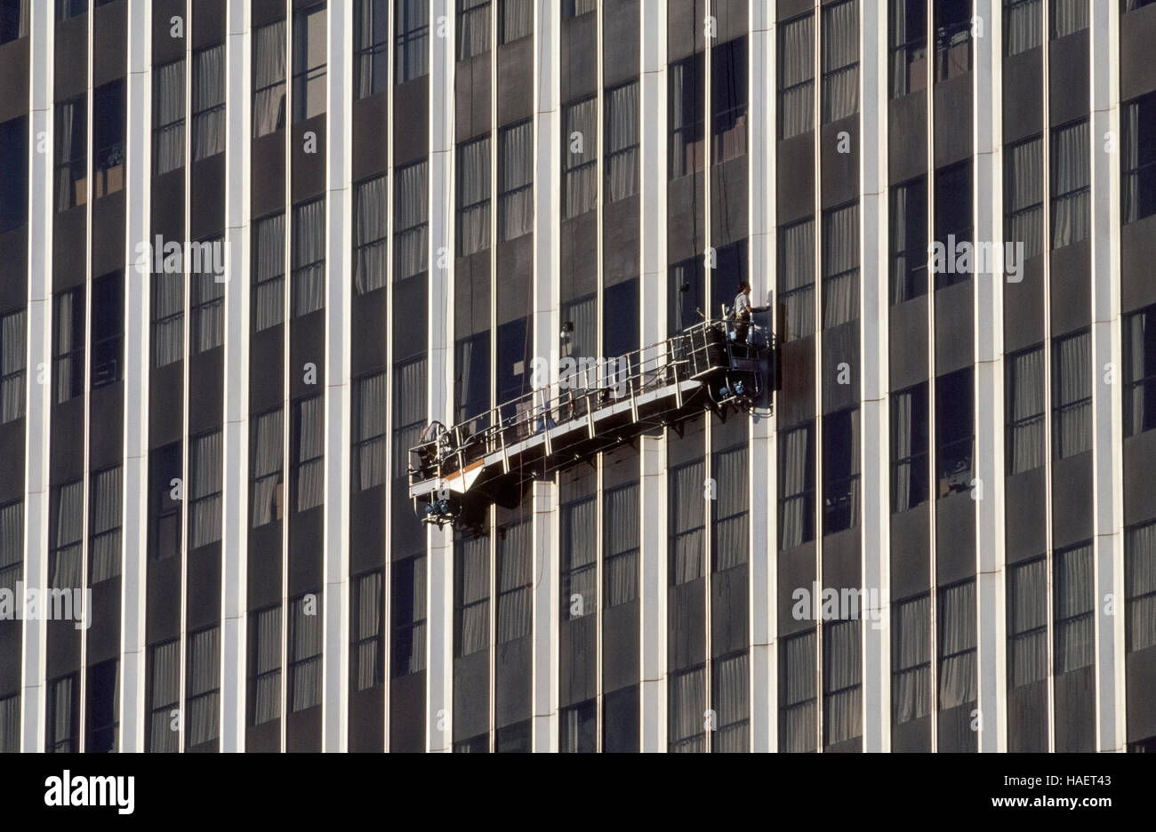 Furchtlos Fenster Reiniger arbeiten hoch über dem Boden aus einem  angehaltenen Gerüst, das ist eine bewegliche Plattform, bekannt als ein  Schaukel-Bühne, die an Drahtseilen steigt vom Dach eines Hochhauses in Los  Angeles,