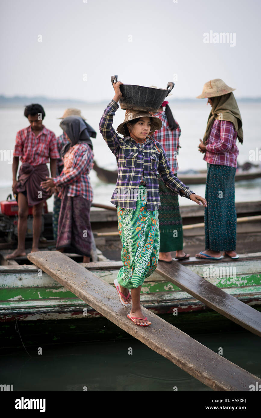 Frauen entladen Kies entlang des Ayeyarwaddy Flusses in der Nähe von Bagan, Myanmar. Stockfoto