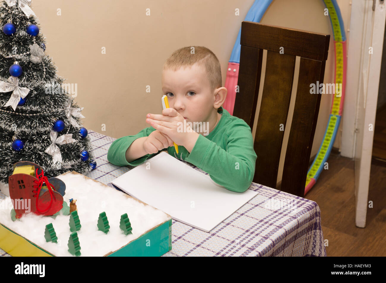 Junge schreibt einen Brief an den Weihnachtsmann brachte ihm Geschenke Stockfoto