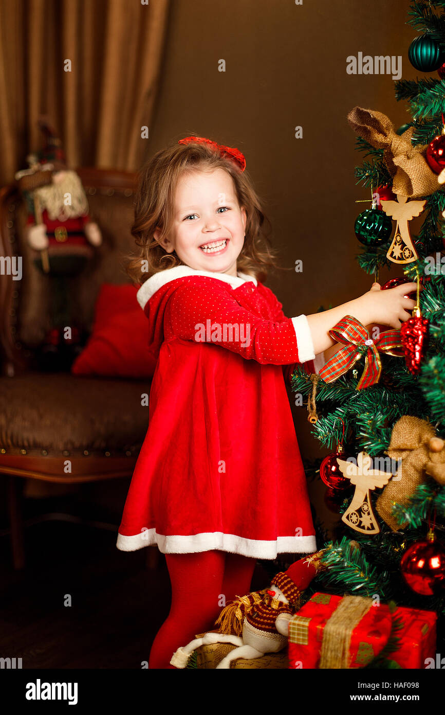 Stehen Mädchen stellt Dekoration zu einem Weihnachtsbaum. Vertikale ind Stockfoto