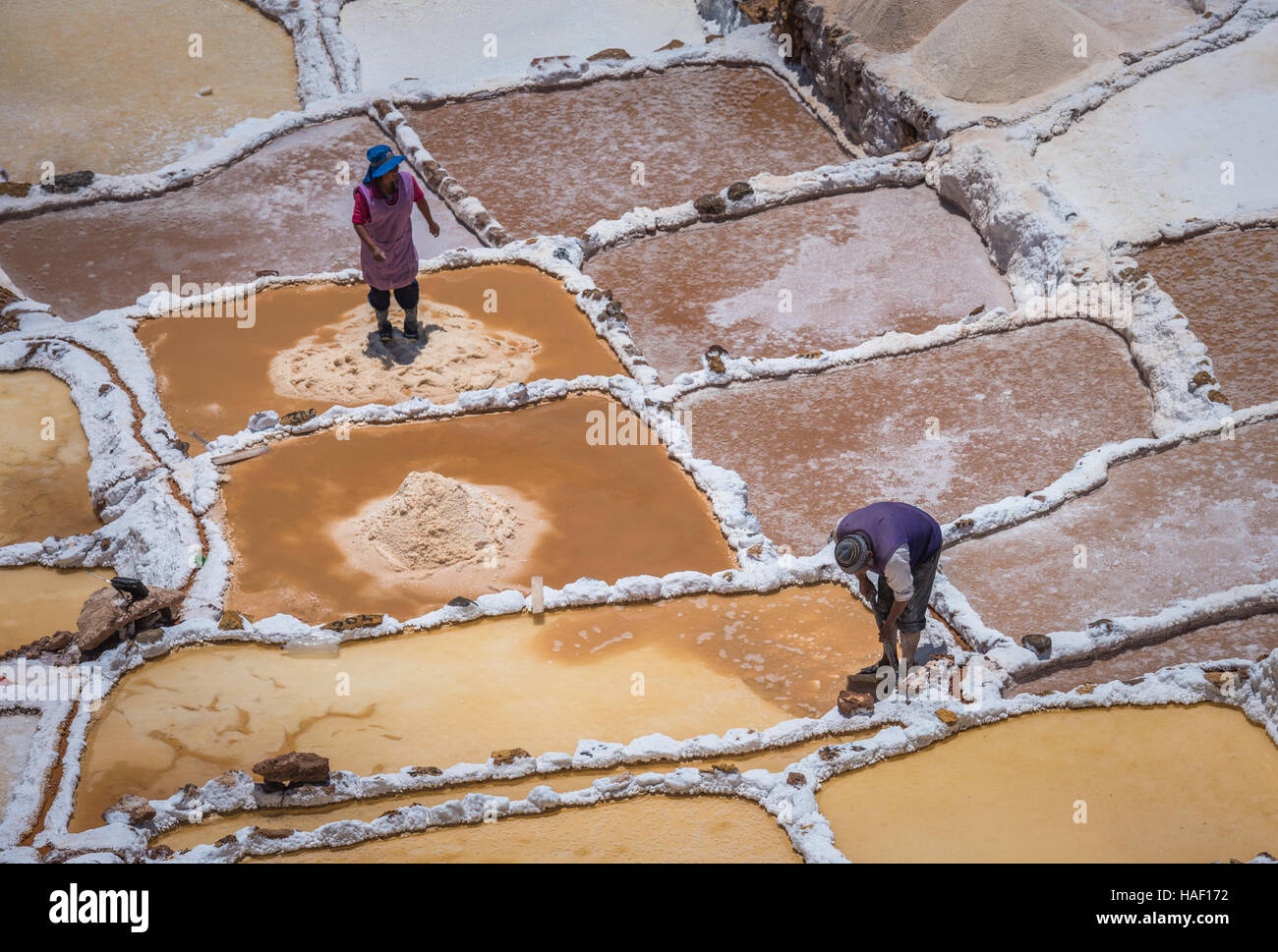 SALINAS DE MARAS, PERU - 12. Oktober 2015: Arbeitnehmer, die Gewinnung von Salz in Salinas de Maras, in der Nähe von vom Menschen verursachten Salzminen Cusco, Peru Stockfoto