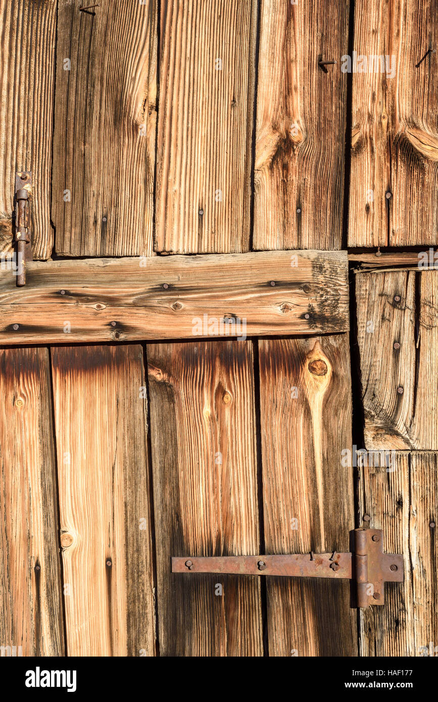 Rostiges Metall Scharnier auf Alter verblasst Holz in braun. Vertikale Zusammensetzung von Fading Holz und eine Türöffnung Eingang. Stockfoto