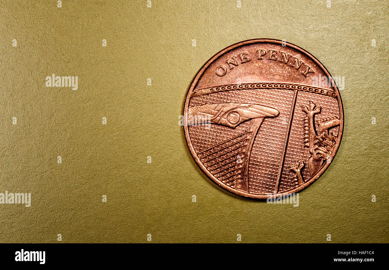Einen Penny englische Währung Münze in einem Makro Nahaufnahme auf seinen luxuriösen goldenen Hintergrund. Exemplar-Bereich für Finanzwirtschaft, Banken und Wirtschaft designs Stockfoto