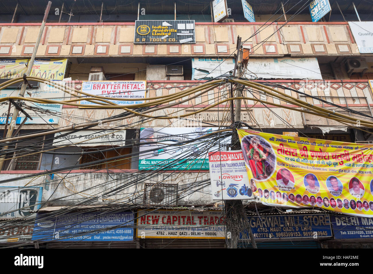 Eine Straße in Old Delhi mit Elektro- und Kommunikationstechnik Verdrahtung außerhalb von Gebäuden, Indien Stockfoto