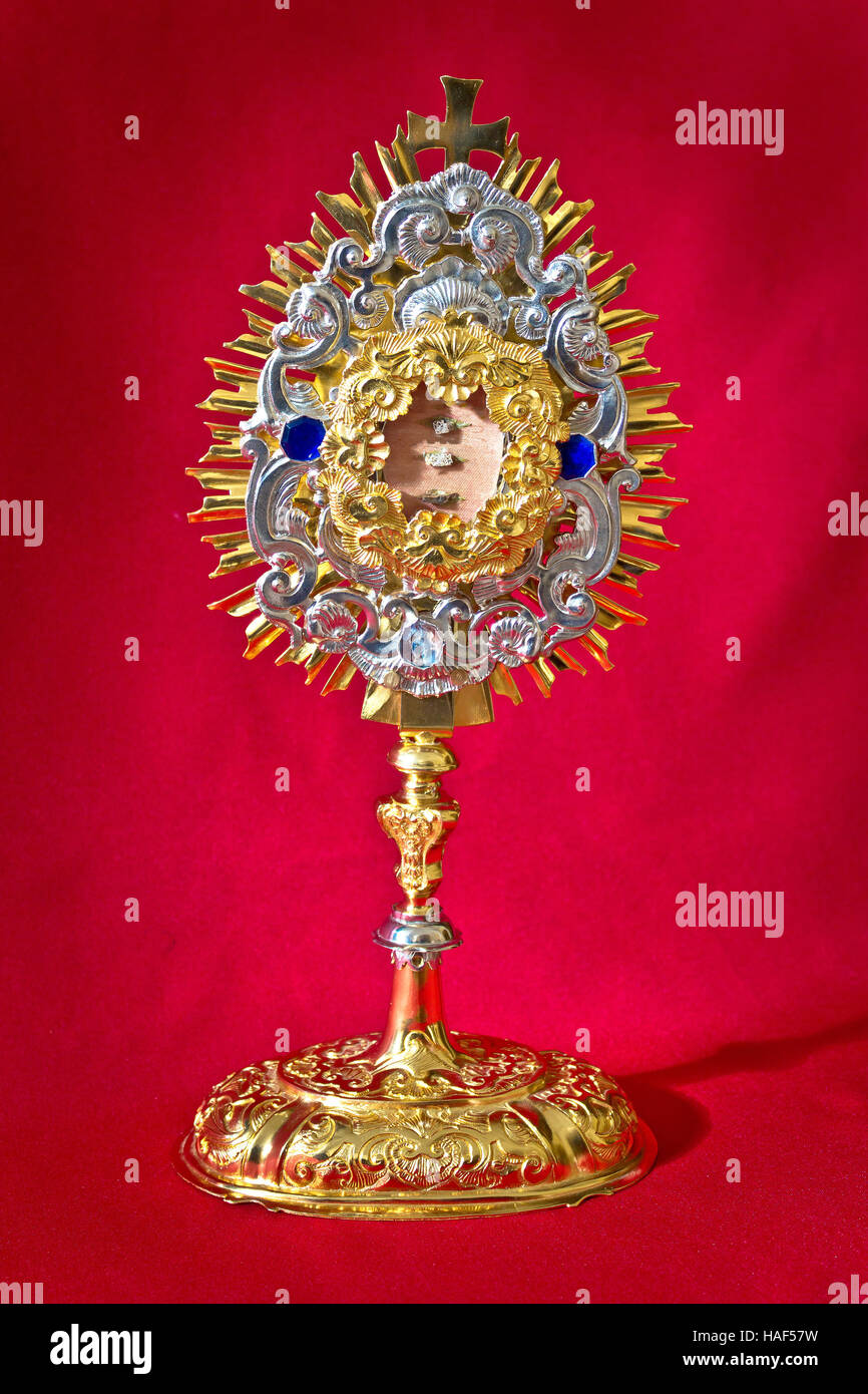 Die goldene Relicquary der katholischen Kirche auf rotem Grund Stockfoto