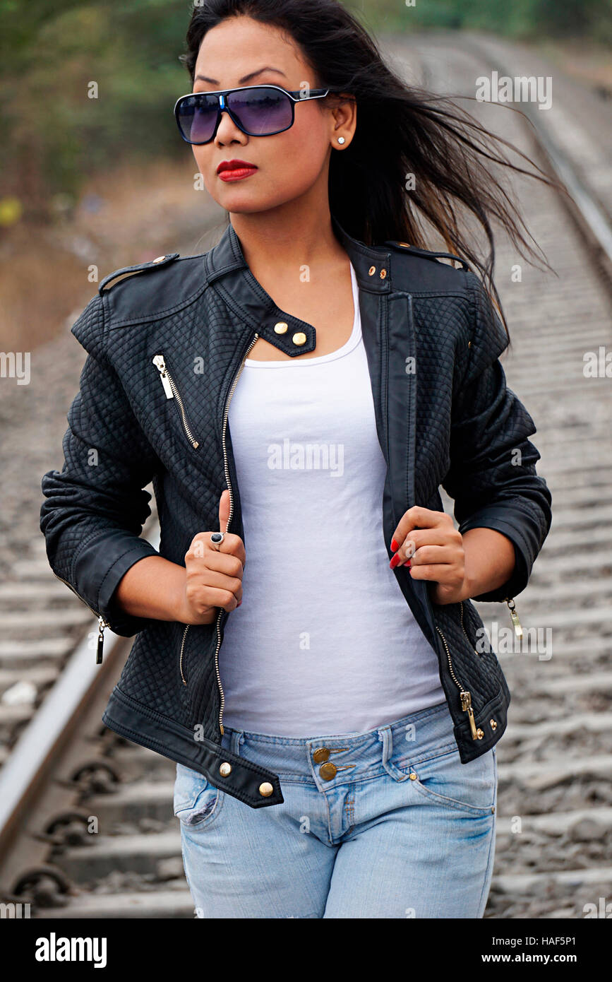 Modische Mädchen mit Jeans und Jacke zu Fuß auf Eisenbahn Spur, Pune, Maharashtra Stockfoto