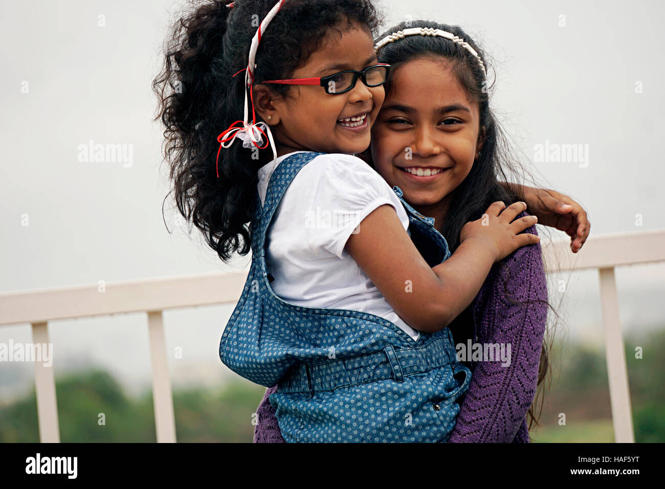 Zwei junge Mädchen umarmen und Lachen, Pune, Maharashtra. Stockfoto