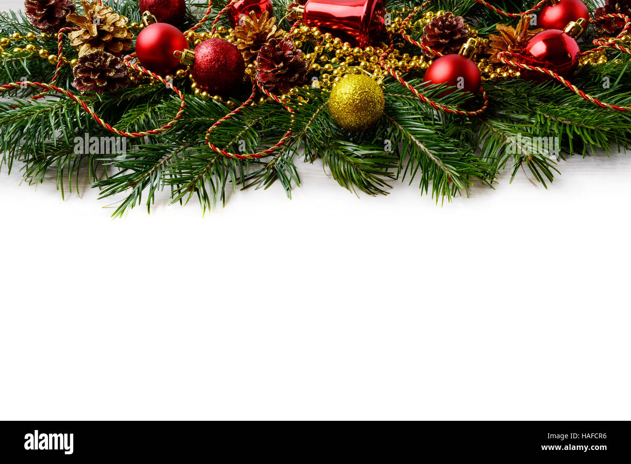 Weihnachten Hintergrund mit roten Verzierungen und goldenen Tannenzapfen dekoriert. Weihnachten Hintergrund mit Tannenzweigen. Kopieren Sie Raum. Stockfoto