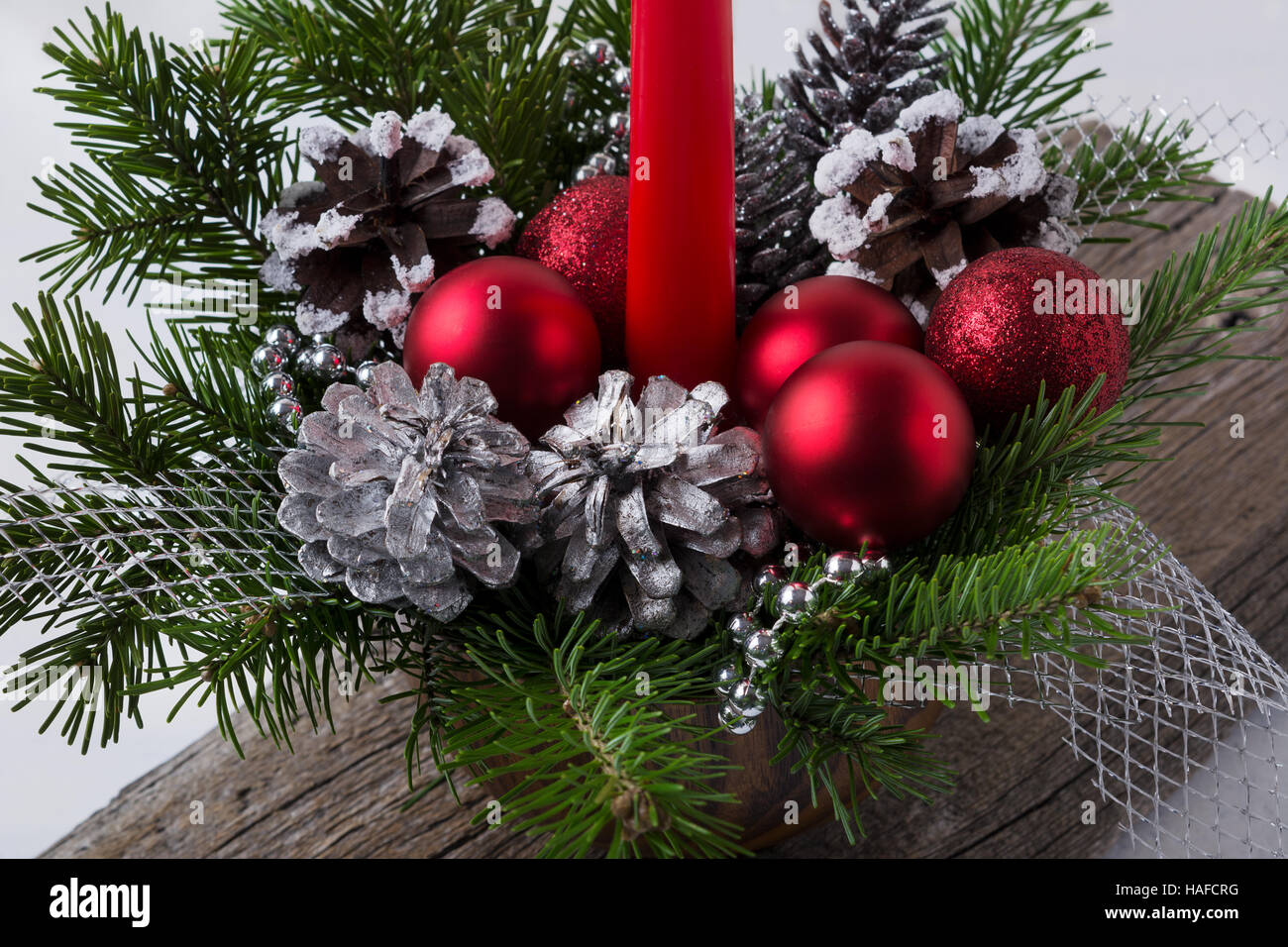 Weihnachts-Dekoration mit roten Verzierungen und silberne Tannenzapfen. Weihnachten-Herzstück mit Silberperlen. Stockfoto