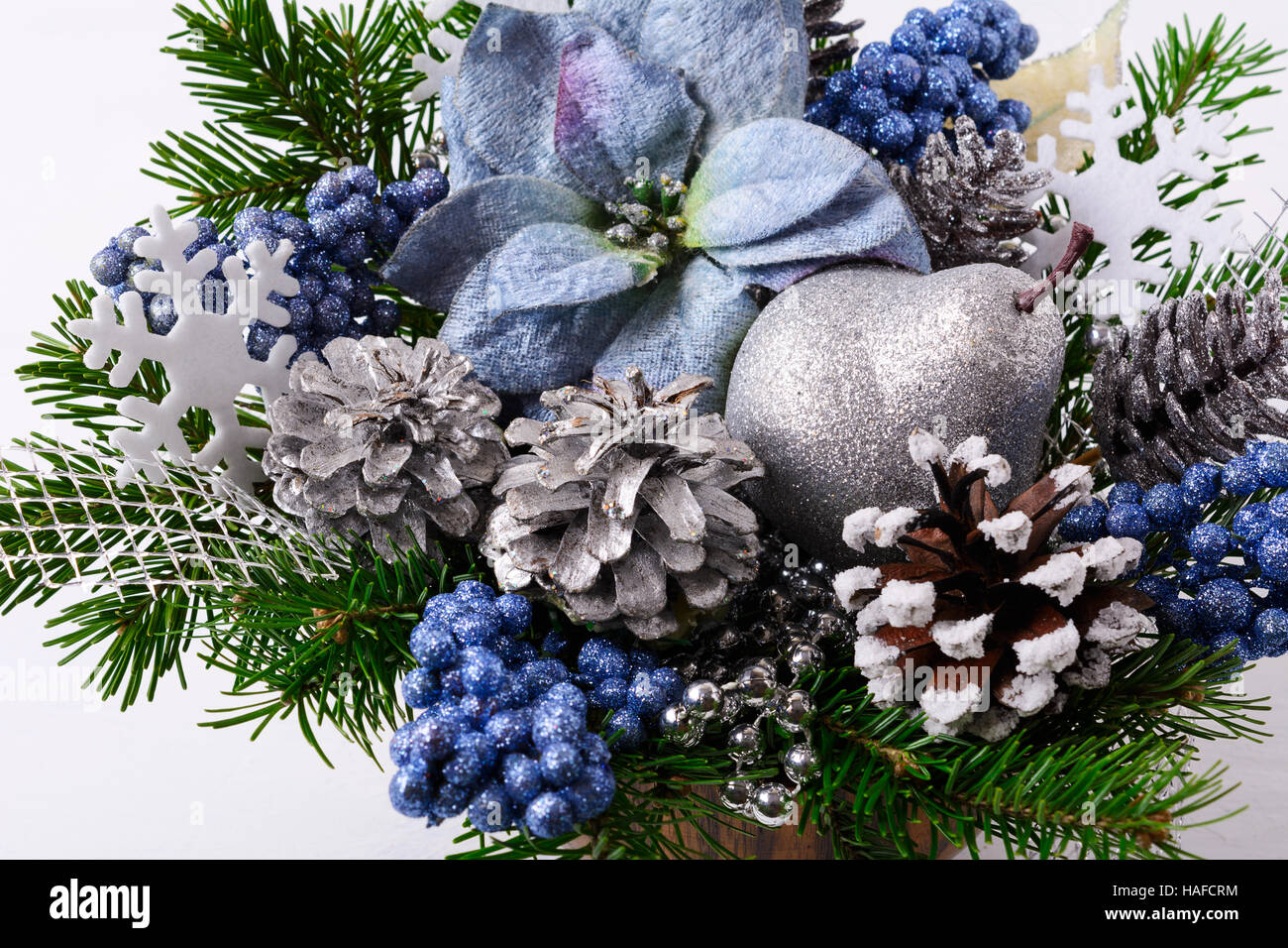 Weihnachten Gesteck mit blauer Seide Weihnachtssternen. Weihnachten Hintergrund mit dekorierten Tannenzapfen. Stockfoto