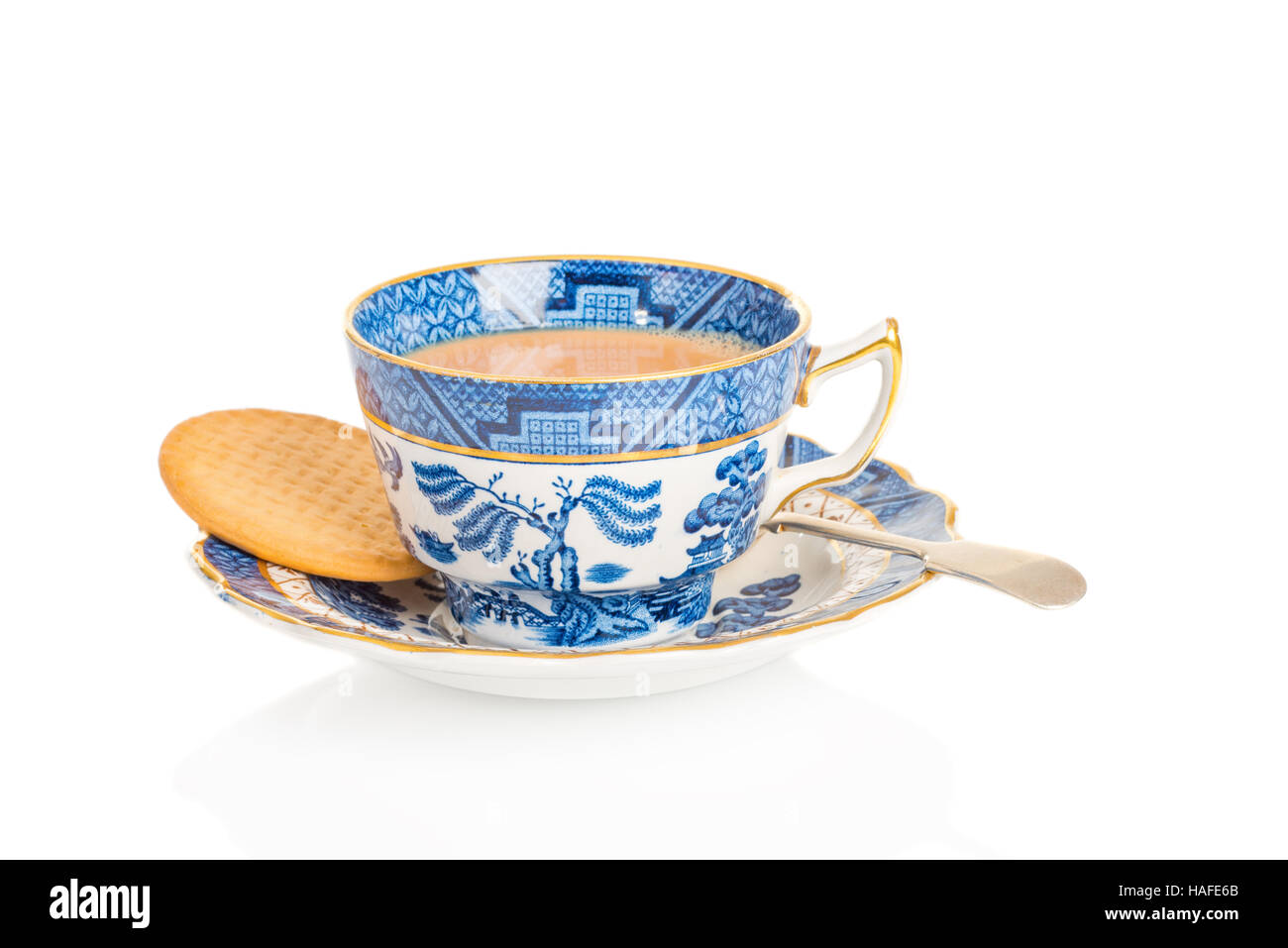 Tasse Tee in einem antiken Teetasse und Untertasse mit Keks auf weißem Hintergrund Stockfoto