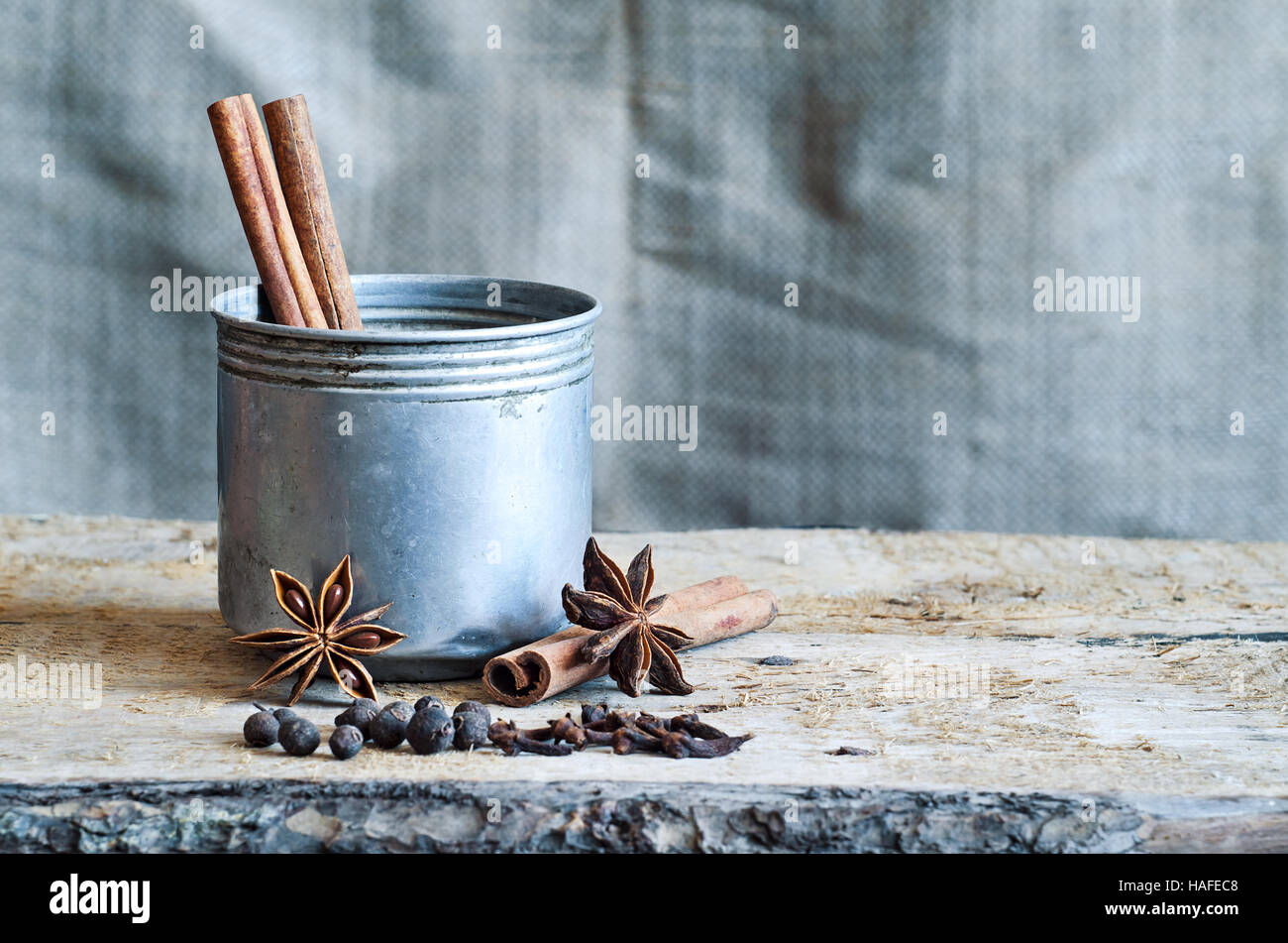 Zutaten für das Kochen Masala Chai oder Glühwein in rustikalen Becher mit Gewürzen auf hölzernen Hintergrund für Winter und Weihnachten. Food-Stillleben-Exemplar. Stockfoto