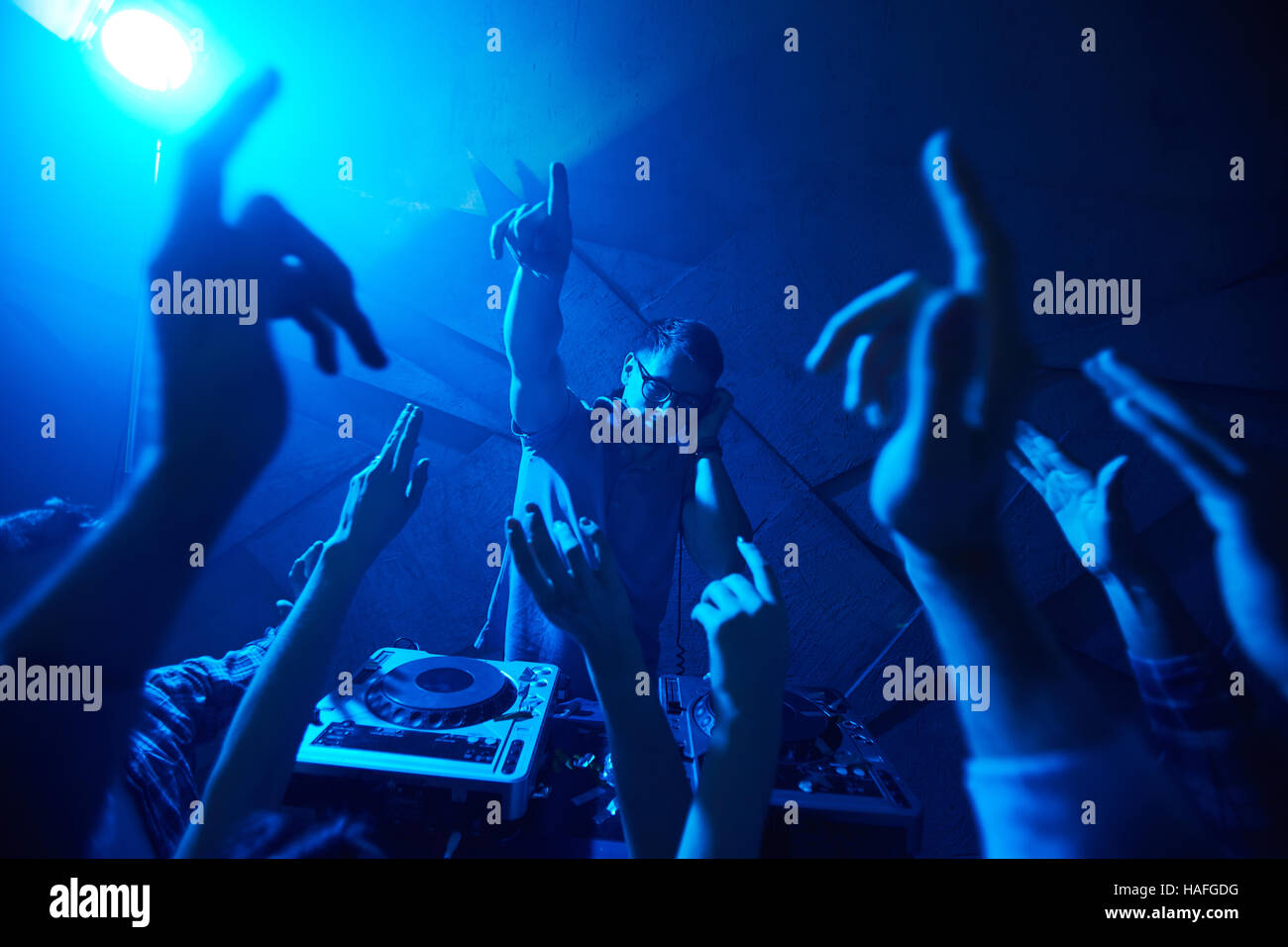 Deejay mit Kopfhörern Musik unter energetischen Tänzer genießen Stockfoto
