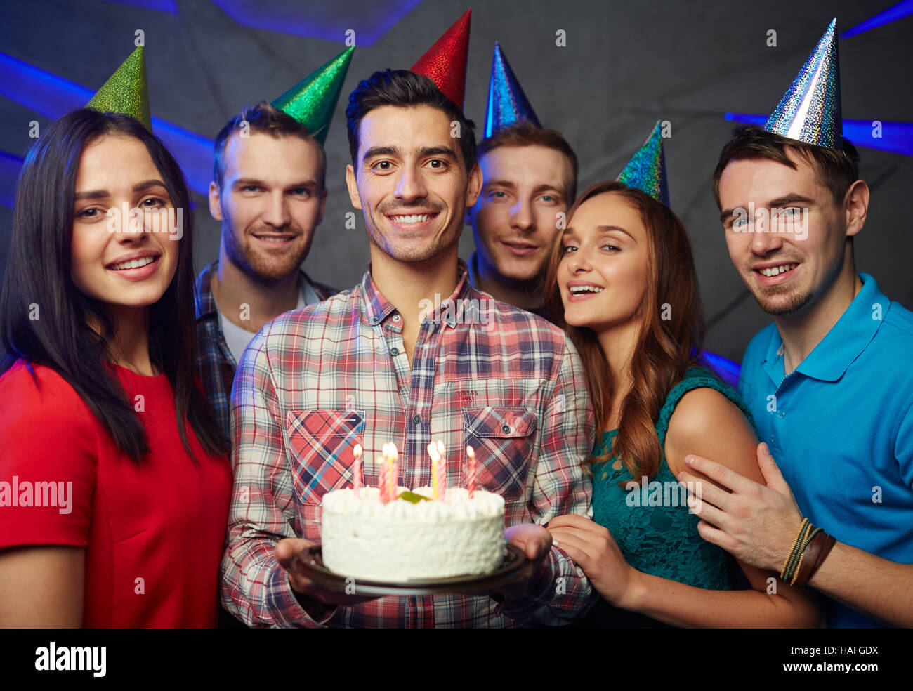 Glücklicher Mann mit Geburtstagstorte und seine Freunde Stockfoto