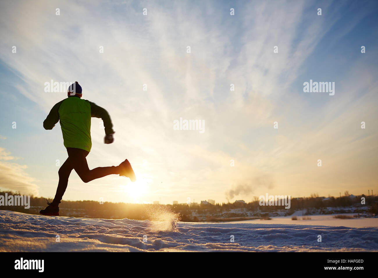 Rückansicht des energetischen Sportler laufen im winter Stockfoto