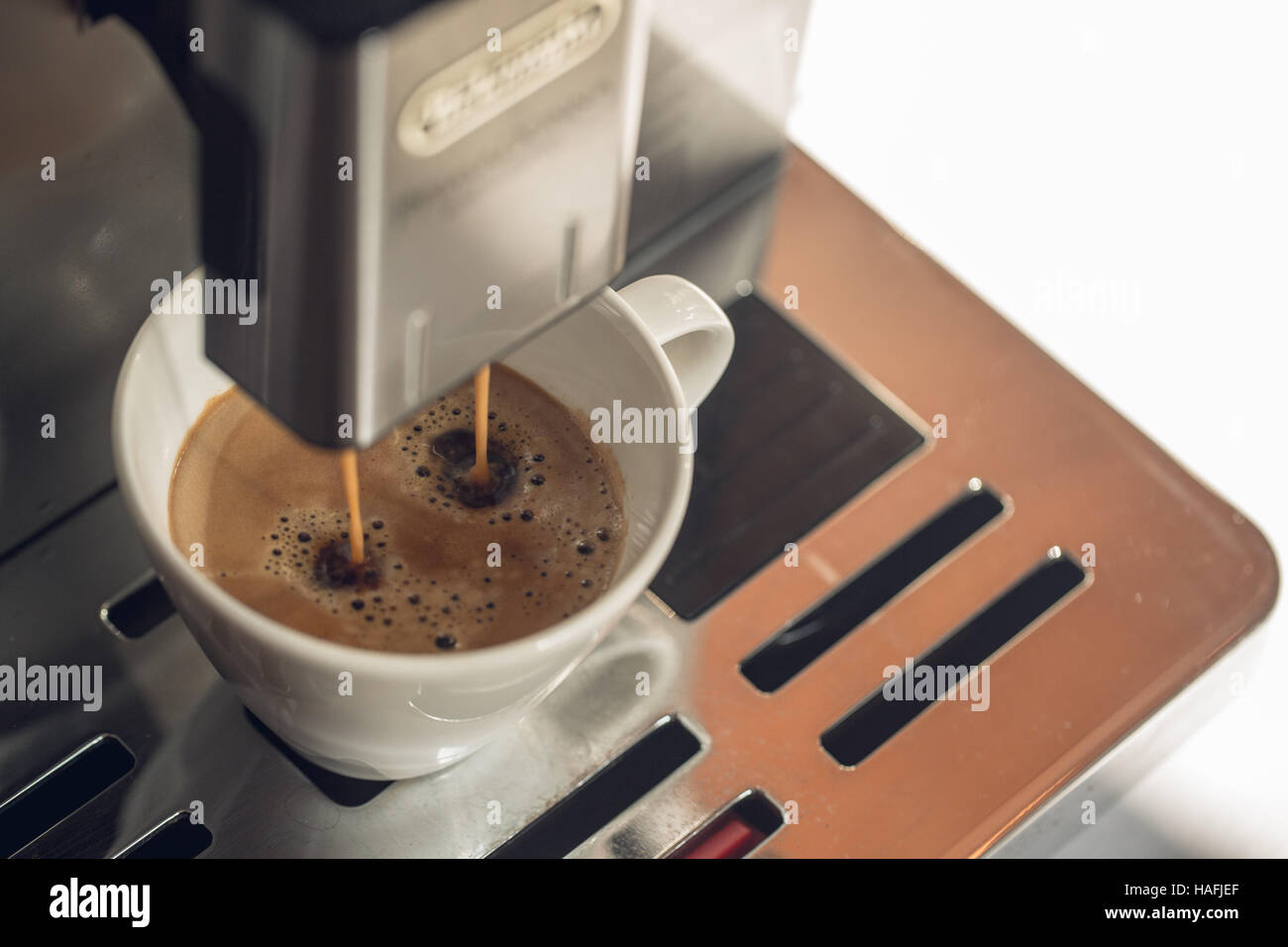 Close-up Kaffee gießen von Kaffeemaschine in weißen Tasse in Restaurant, Bar oder Kneipe. Professionelle Kaffee brauen. Stockfoto