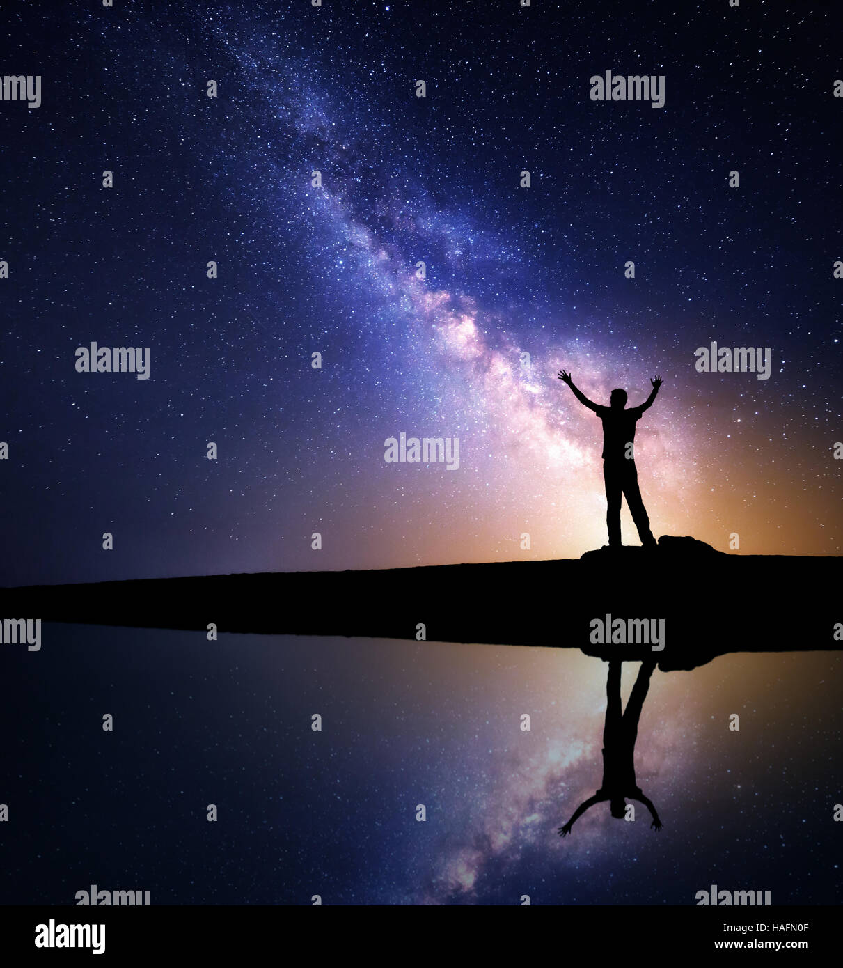 Milky Way. Nacht Himmel mit Sternen und Silhouette des stehenden glücklich mit oben erhobenen Armen auf dem Berg in der Nähe des Sees Stockfoto