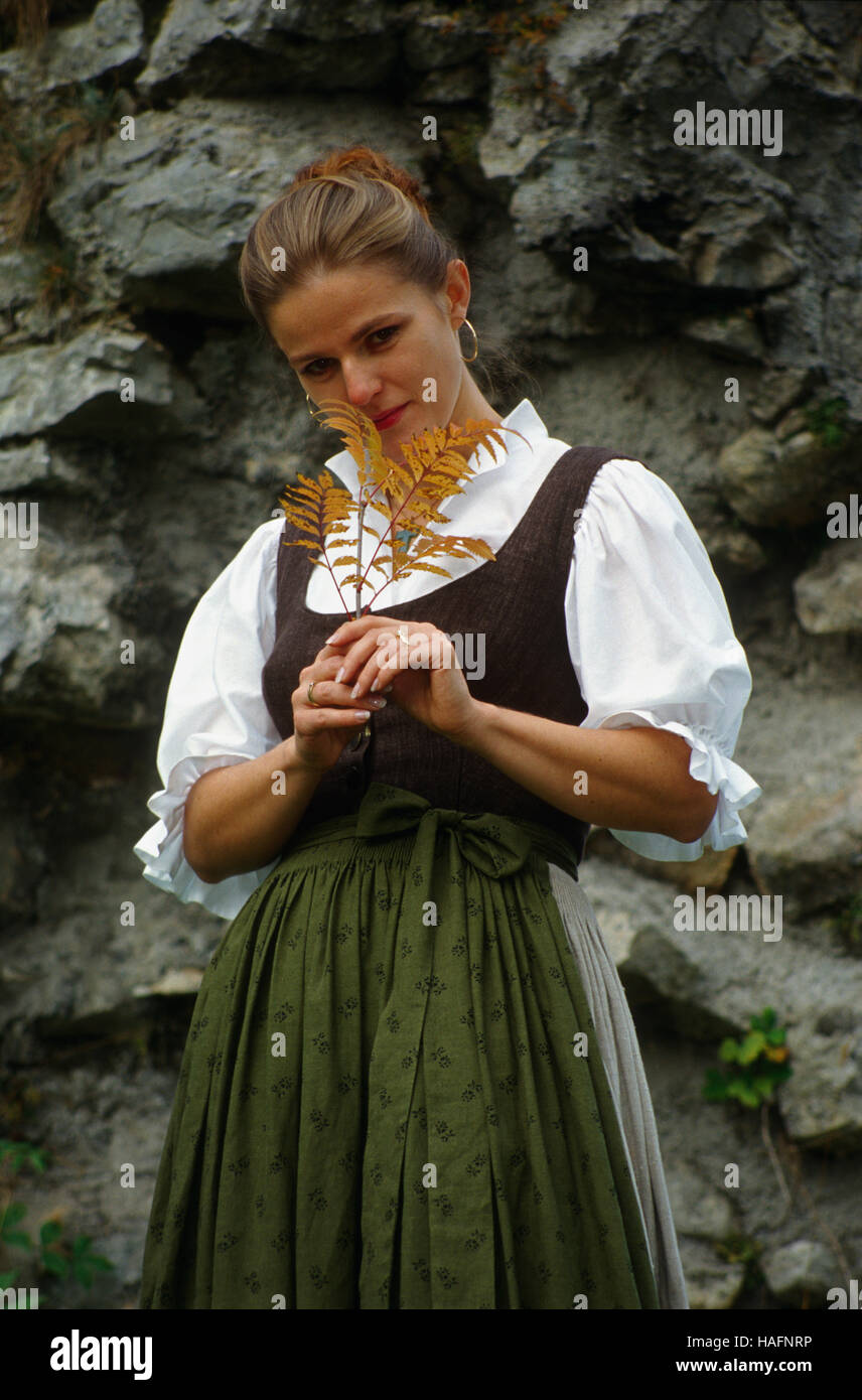 Frau, 30 Jahre alt, tragen traditionelle Kleidung der Stadt Reichraming, posiert vor einem Felsen Gesicht, Österreich, Europa Stockfoto