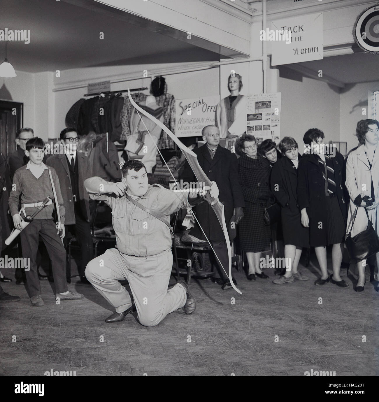 1960er Jahre, eine Demonstration von einer männlichen Archer mit einem Bogen & Pfeil in einem Geschäft das Bogenschießen Produkte von "Jack The Yeoman" entwickelt, England, Großbritannien zu fördern. Stockfoto